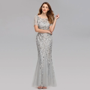 Detailed view of leaf pattern sequins and sheer mesh mermaid hem on grey evening gown