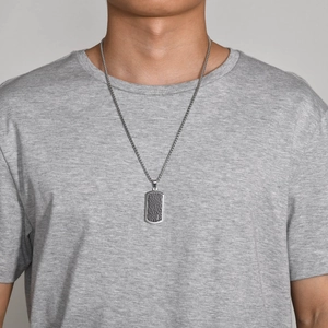 Close-up of men's titanium steel military tag necklace with woven chain on a male model
