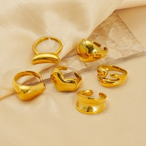Detail of diverse gold chunky ring set with polished metallic finish on silk fabric