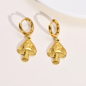 Detailed view of golden mushroom charm earrings with textured caps and polished hoops