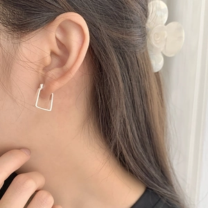 Close-up of elegant square S925 sterling silver drop earrings worn by a model