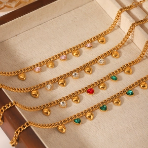 Détail de quatre bracelets gourmettes dorés avec zircons en cœur rose blanc rouge vert