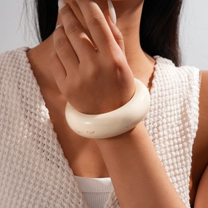 Close-up of minimalist cream resin bangle with smooth matte finish on female wrist