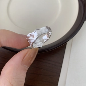 Close-up of S925 sterling silver ring featuring irregular hammered texture and hallmark
