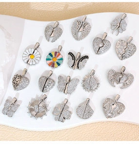 Macro detail of micro-pave cubic zirconia heart and wing pendants on display