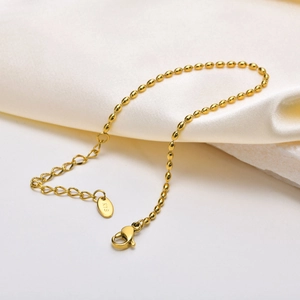 Detail of 18K gold stainless steel olive bead bracelet with lobster clasp and K18 hallmark