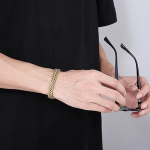 Detail eines goldenen doppelreihigen Drachenschuppen-Armbands an einem männlichen Model