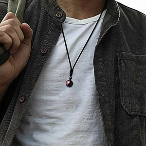 Reddish-brown tiger eye stone pendant on black woven cord worn by a male model