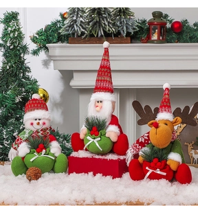 Close-up of Santa, Snowman and Reindeer plush dolls with pine branch gift bags