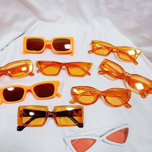 Retro round frame orange and amber sunglasses collection displayed on white fabric