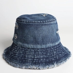 Close-up of distressed denim bucket hat featuring ripped details and raw frayed edges