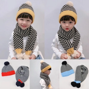 Dettaglio macro del set di cappello e sciarpa in maglia a righe per bambini con pompon