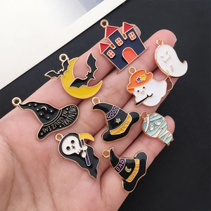 Set of 8 Halloween enamel charms held in hand showing wizard hat and ghost details