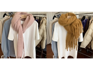 Detail view of pink and brown thick knit scarves with fringe on a mannequin
