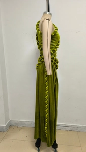 Detailed view of olive green velvet evening dress with side braided knot design on mannequin