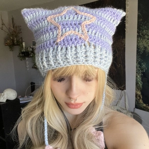 Detail of lavender knit cat ear hat featuring striped crochet texture and pink stars