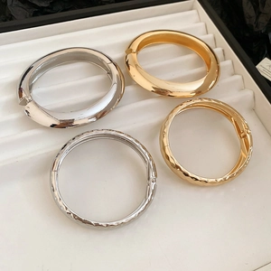 Vue détaillée de quatre bracelets métalliques aux textures lisses et facettées