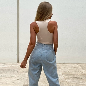 Back view of beige ribbed racerback bodysuit with high waist loose light blue jeans