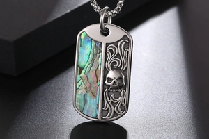 Macro shot of titanium steel dog tag pendant featuring iridescent shell and skull engraving