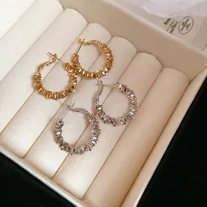 Irregular textured silver and gold hoop earrings in minimalist C-shape design