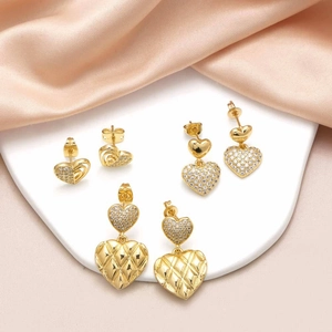 Three pairs of golden heart earrings with pavé zircon and quilted pattern details