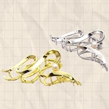 Detail of gold and silver metallic star claw clips with pearl accents and twisted design