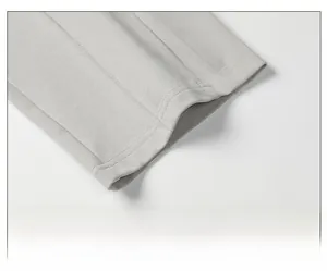 Detailed close-up of loose-fitting hem on light grey men's casual knit trousers