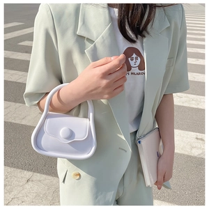 Minimalist white mini jelly bag shown on street with chain strap for size reference