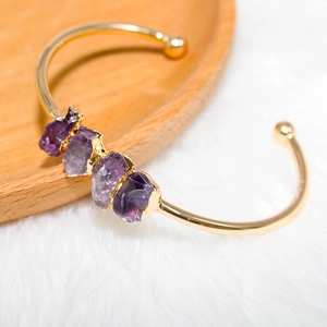 Detail of amethyst clusters on gold-plated adjustable cuff bracelet with natural stones