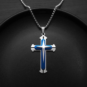 Three-layer silver cross pendant necklace with blue inlay on a sleek black display