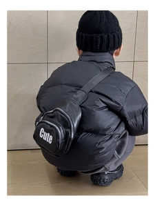 Back view of a child wearing the black leather crossbody chest bag with white Cute lettering