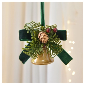 Detail of Christmas ornament featuring golden bells, green velvet bow and pine cones