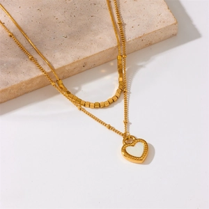 Gold-plated double layer heart pendant necklace with white shell inlay on stone display