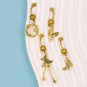 Details von vier goldenen Bauchnabelpiercings mit Mond, Schmetterling und Sternen