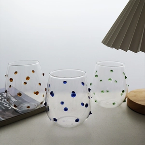 Irregular glass tumblers with colorful 3D dots for juice and milk in home setting