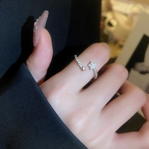 Detail of silver star and snowflake adjustable ring with zircon stones on model finger