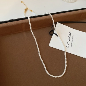 Detail of elegant pearl necklace with gold clasp and extension chain on velvet