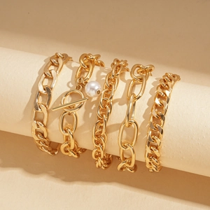 Detailed close-up of 5-piece gold chain bracelet set with pearl and OT buckle on stands
