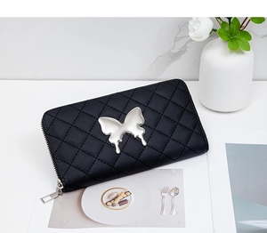 Close-up of black quilted leather long wallet with silver butterfly ornament and zipper