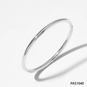 Top view of minimalist polished silver bangle with smooth mirror finish on white background
