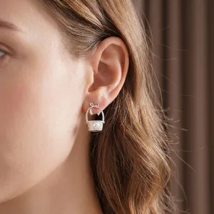 Elegant silver bow basket earrings on model with sophisticated weaving detail