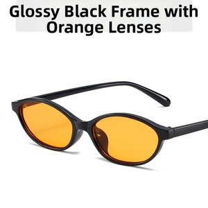 Detail of oval black frame sunglasses with vibrant orange transparent lenses in Y2K style
