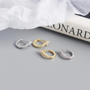 Detail of S925 sterling silver hoop earrings with floral zircon accents in gold and silver