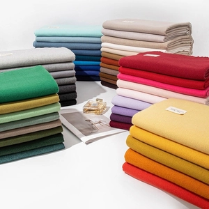 Assorted solid color cashmere-feel winter scarves stacked in multiple vibrant shades