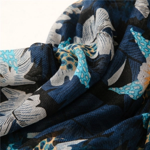 Macro detail of navy cotton-linen scarf showing soft texture and blue leaf pattern