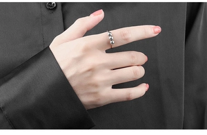 Detail of silver spinner ring with three sliding beads worn on the index finger