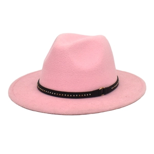 Detailed view of a pink wool fedora hat with black studded band and gold metal ring