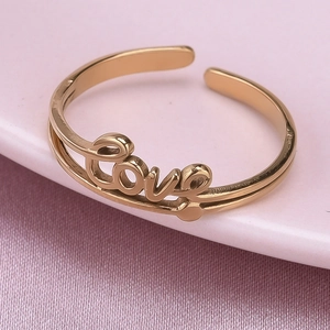 Close-up of golden stainless steel open ring with elegant cursive love lettering