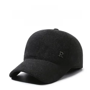 Detail of winter baseball cap showing thick wool fabric and metal 'R' emblem with ear flaps