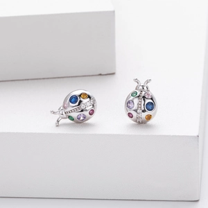Detailed macro view of 925 sterling silver ladybug stud earrings with colorful gemstones